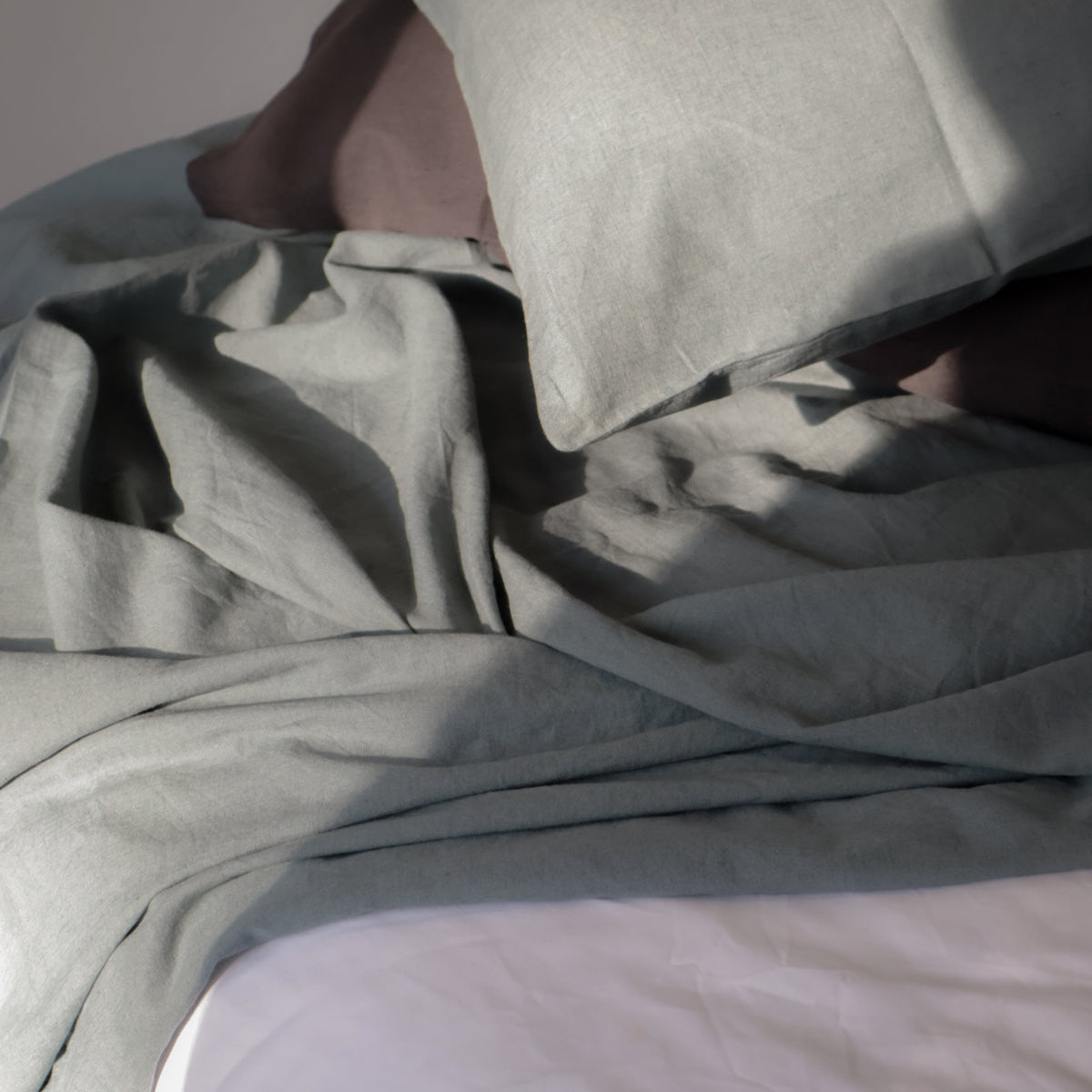 Gray bedding set with a pillow on a neutral background